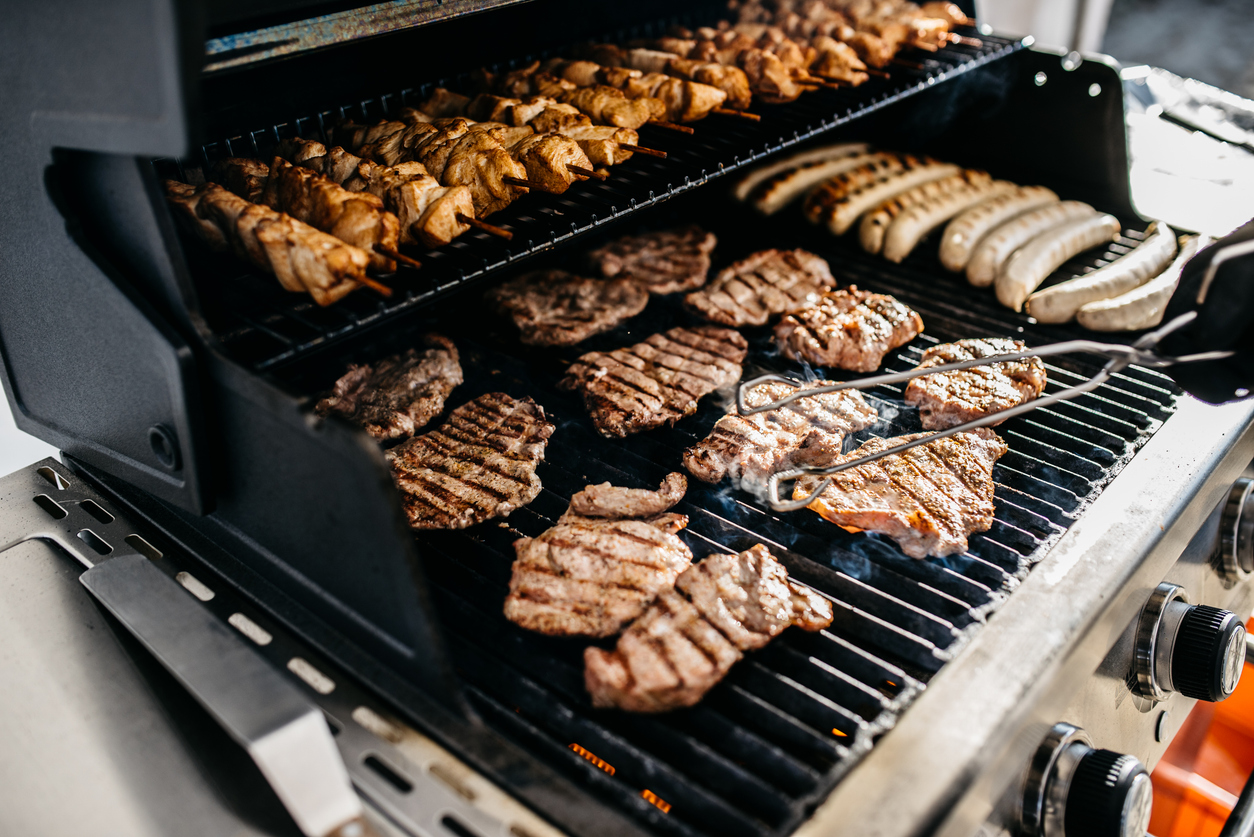 Grillplatte mit verschiedenen Fleischsorten und Würstchen.